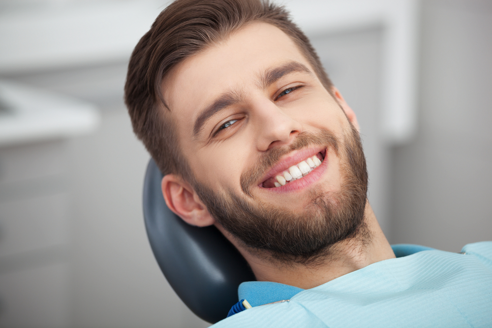 A man sitting in a dentist chair for Regular Dental Checkups